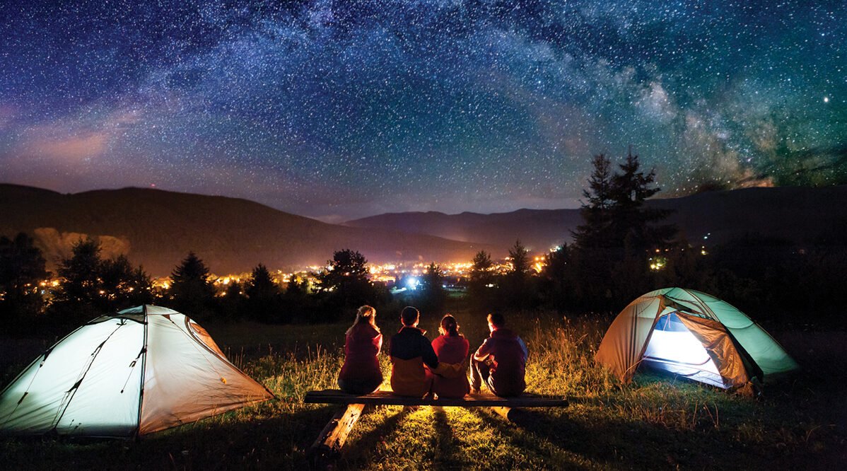A family camping together in the mountains, showing the importance of selecting a campsite for comfort and safety.
