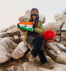 Vamini, an Indian climber, celebrating at one of the mountain summits during an expedition with Wild Pro Adventures